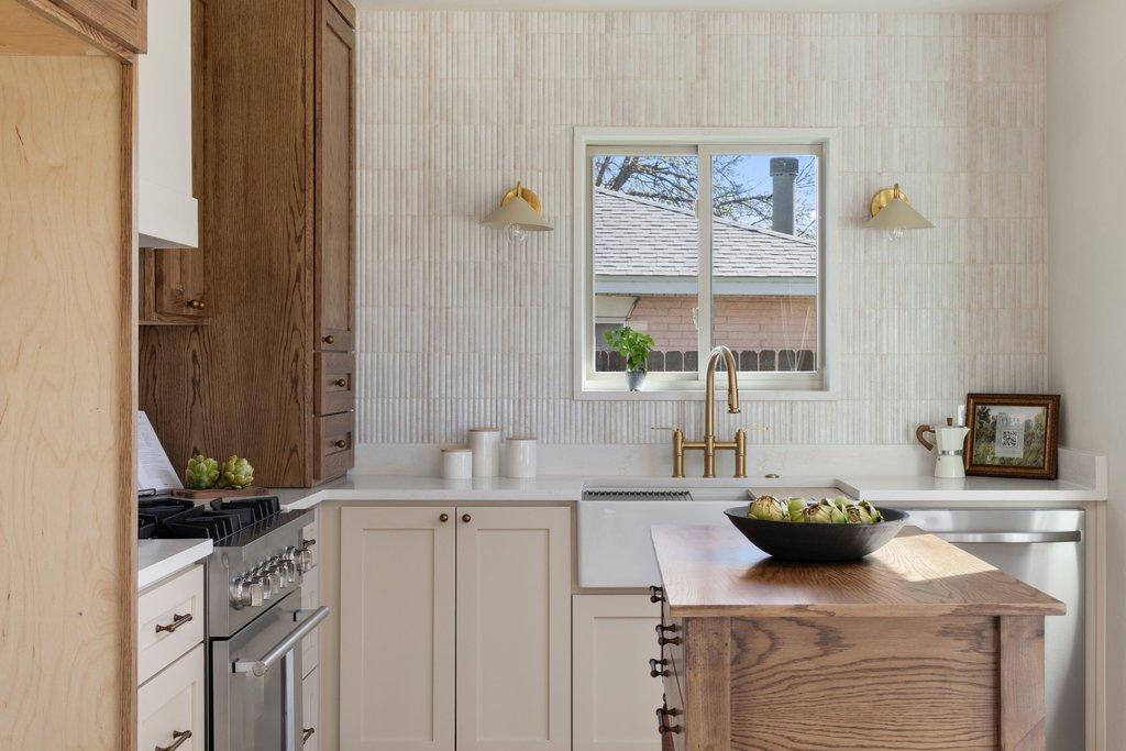 5213 Buffalo Pass Austin, TX 78745 - Photo 9 of 26 Beautifully curated kitchen with custom cabinetry, stone surfaces, and wall-to-wall tile.