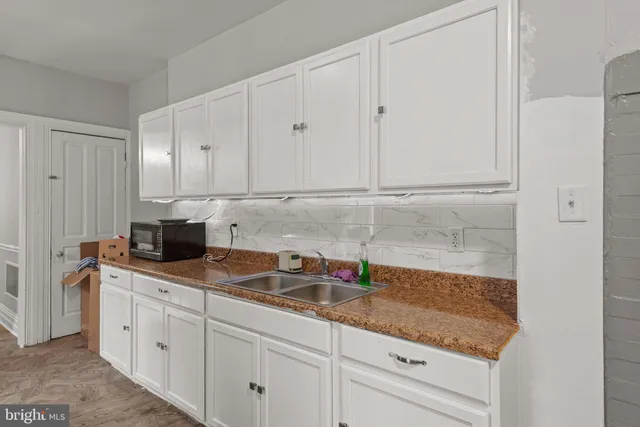 a kitchen with granite countertop white cabinets and white appliances