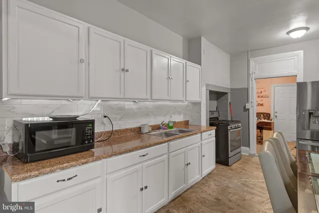 a kitchen with stainless steel appliances granite countertop a refrigerator sink and stove