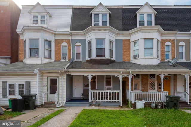 front view of a brick house with a yard