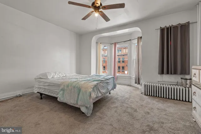 a spacious bedroom with a bed and a window