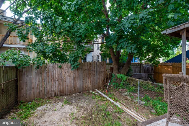 a backyard of a house with plants and wooden fence