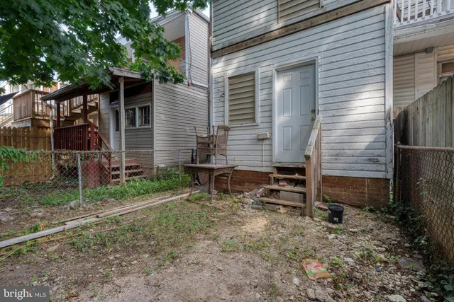 a view of house with backyard and chairs