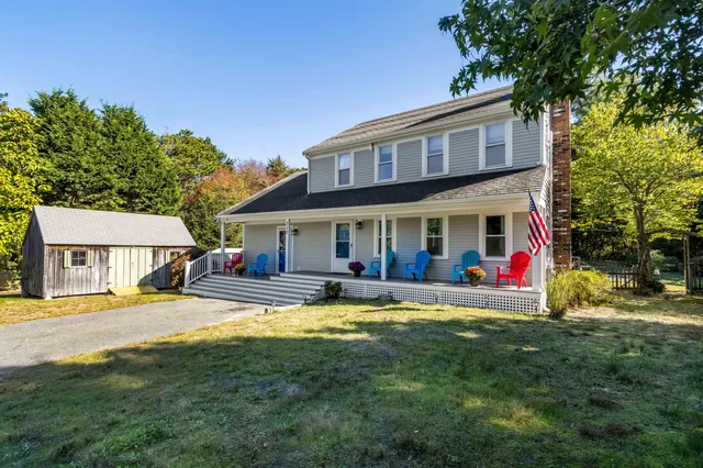 a view of a house with a patio and a yard