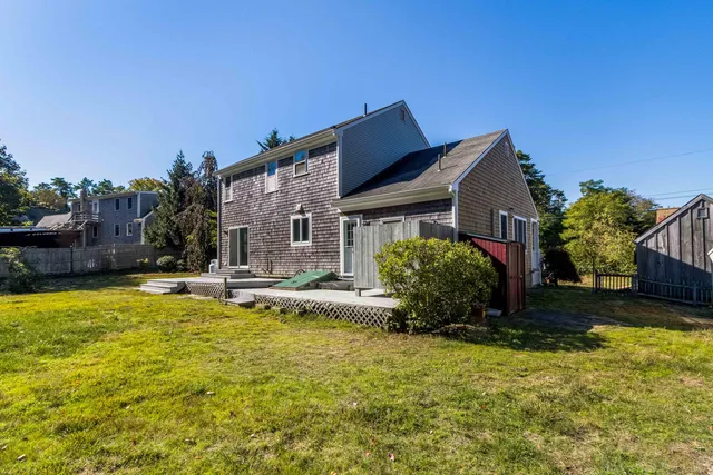 a view of a house with backyard and wooden roof