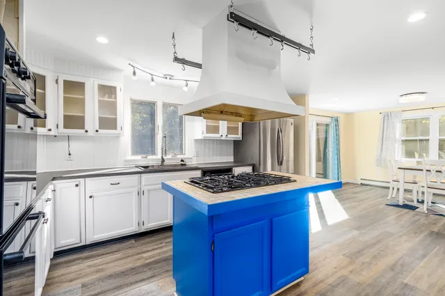 a kitchen with stainless steel appliances a stove sink and wooden floor