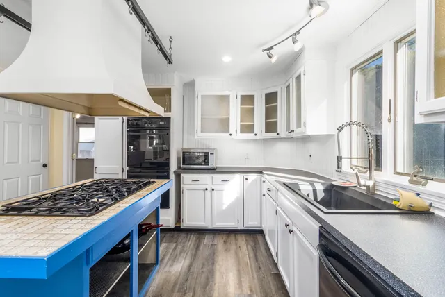 a kitchen with a sink stove top oven and cabinets