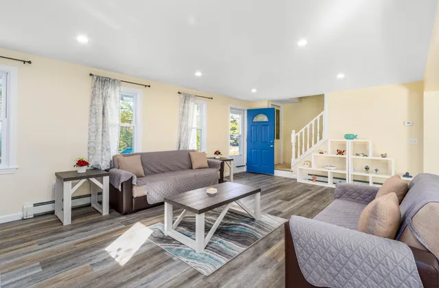 a living room with furniture wooden floor and a large window