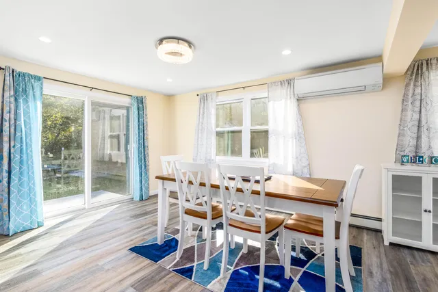 a dining room with wooden floor and window