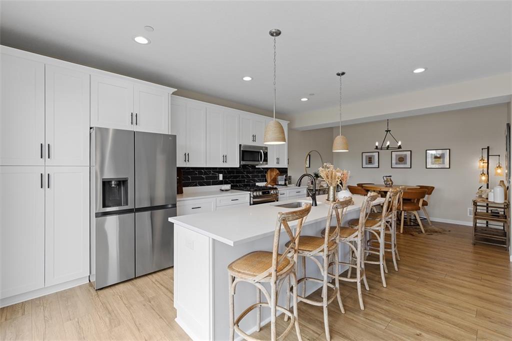 403 Walnut Court Pittsburgh, PA 15237 - Photo 13 of 42 a kitchen with stainless steel appliances a refrigerator a stove a sink a dining table and chairs with wooden floor