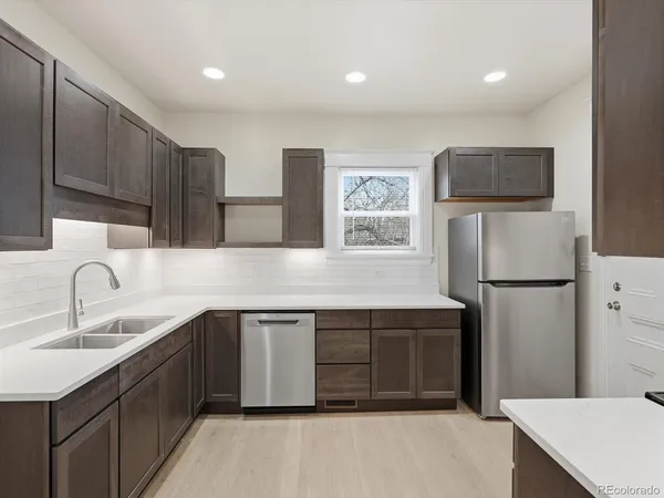a kitchen with stainless steel appliances a refrigerator sink and cabinets
