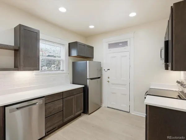 a kitchen with refrigerator cabinets and wooden floor