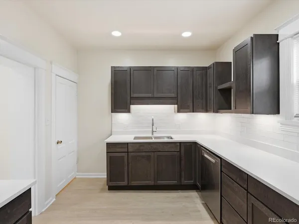 a kitchen with stainless steel appliances granite countertop a sink and a refrigerator