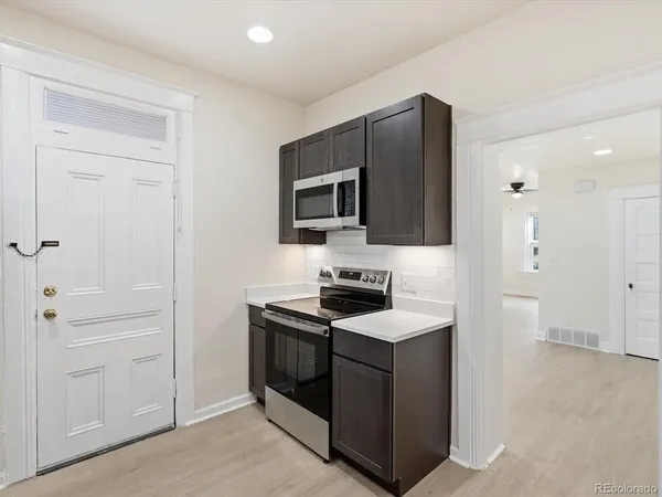 a kitchen with stainless steel appliances granite countertop a refrigerator and a stove top oven