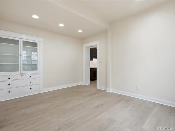 an empty room with cabinet and mirrors