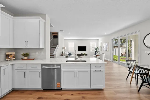 a kitchen with a sink cabinets and wooden floor