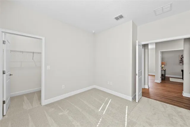 a view of a room with wooden floor and a bathroom