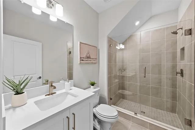 a bathroom with a sink a toilet a glass door a shower and a mirror