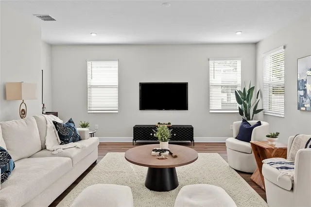 a living room with furniture a window and a flat screen tv
