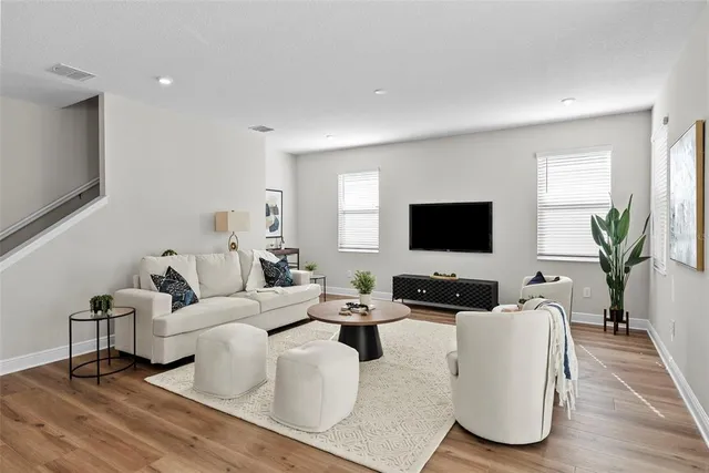 a living room with furniture wooden floor and a flat screen tv