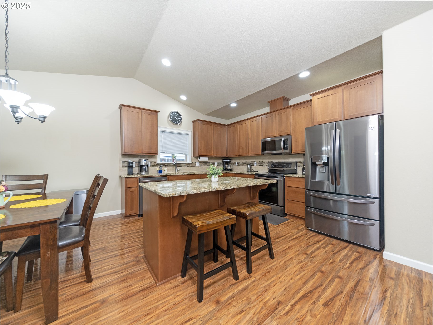 1020 East Fourth Street Yamhill, OR 97148 - Photo 15 of 46 a kitchen with stainless steel appliances a refrigerator a stove a dining table and chairs with wooden floor