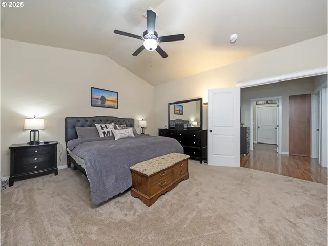 a spacious bedroom with a bed and ceiling fan