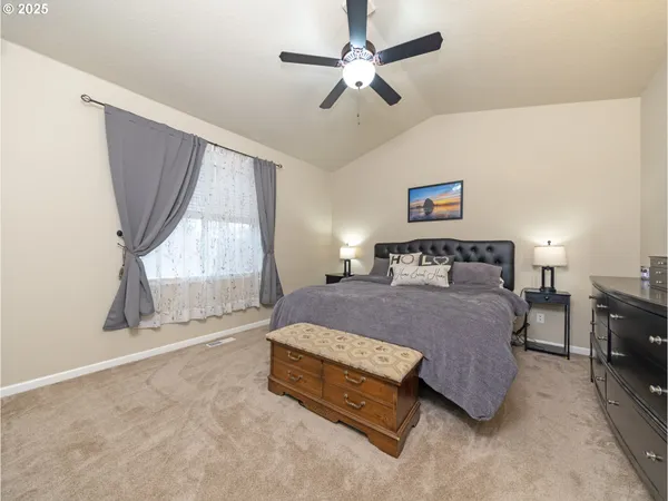 a spacious bedroom with a bed a window and a chandelier