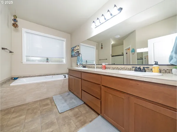 a spacious bathroom with a tub sink and mirror