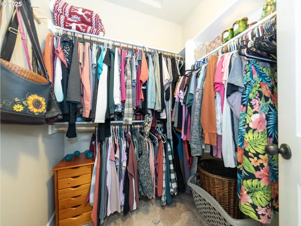 a view of walk in closet with clothes