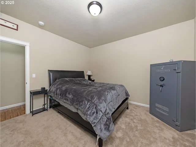 a bedroom with a bed and painting on the wall