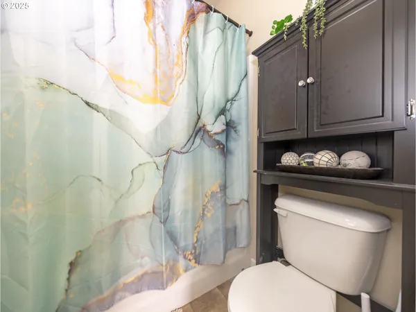 a bathroom with a toilet and a shower curtain