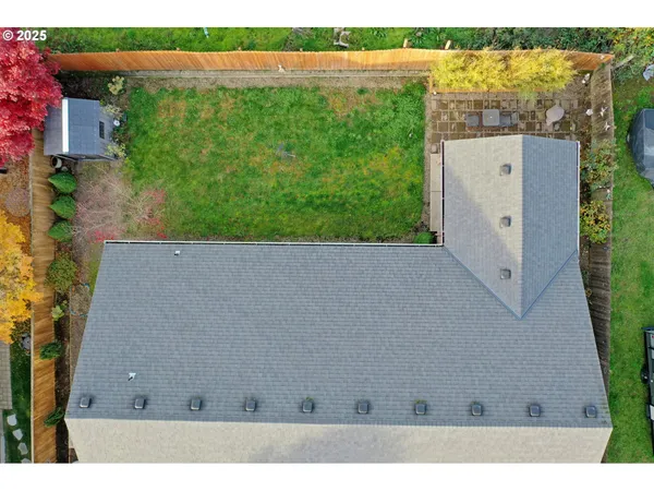 an aerial view of a house with a yard and lake view