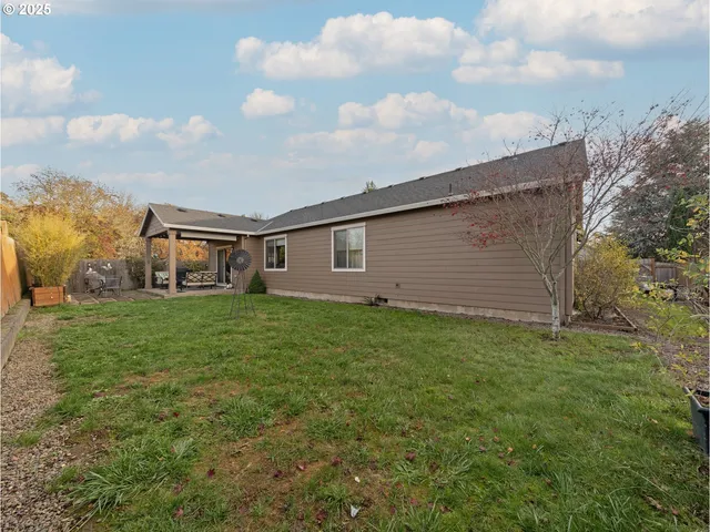 a view of a backyard with plants and large trees