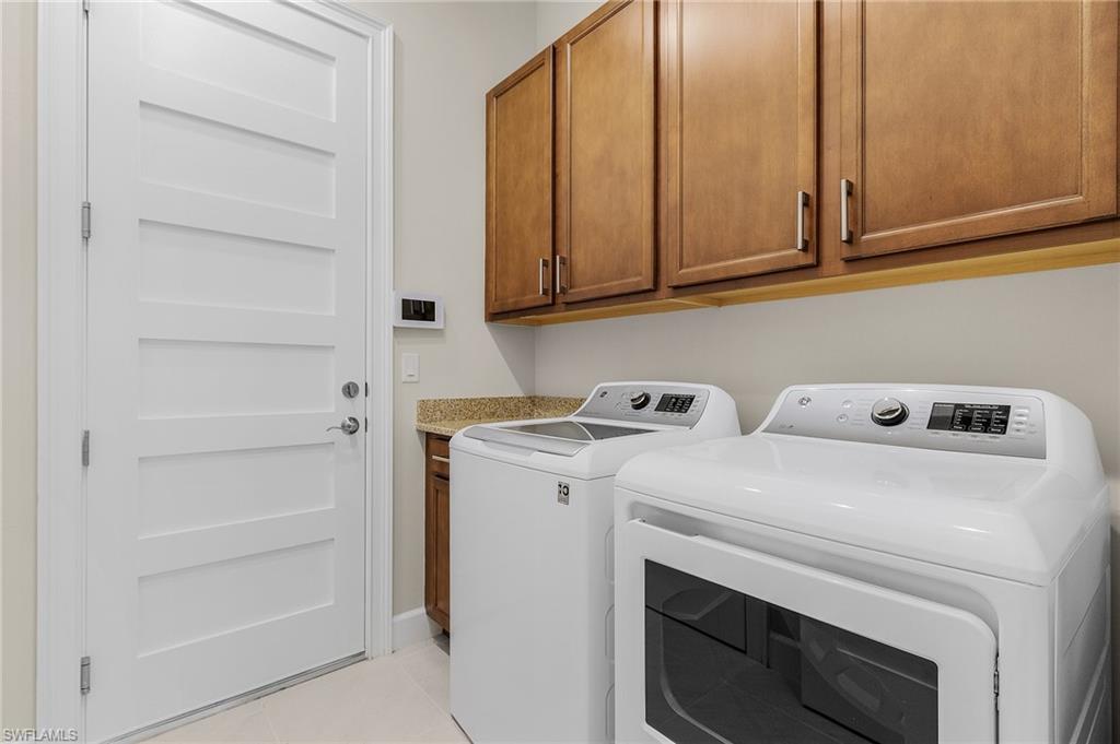 5731 Highbourne Drive Naples, FL 34113 - Photo 13 of 20 Laundry room featuring cabinets, washing machine and dryer