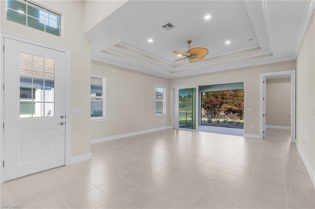 5731 Highbourne Drive Naples, FL 34113 - Photo 3 of 20 Entryway featuring a tray ceiling, ceiling fan, plenty of natural light, and ornamental molding