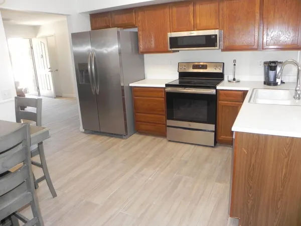 a kitchen with granite countertop a refrigerator and a stove top oven