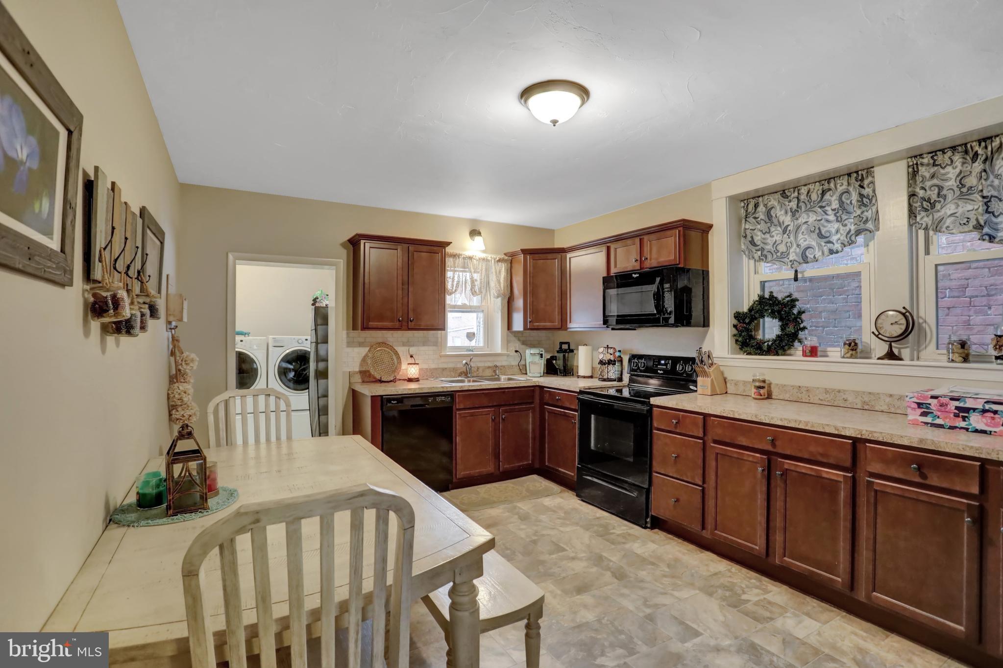 59 South Main Street Spring Grove, PA 17362 - Photo 11 of 50 a kitchen with stainless steel appliances granite countertop a stove top oven a sink dishwasher a dining table and chairs with wooden floor