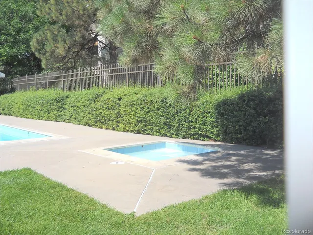 a view of a yard with plants and large trees