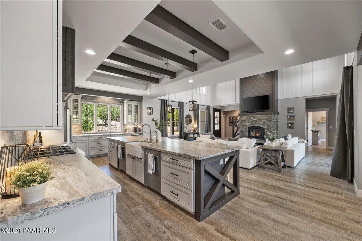 1947 Shadow Valley Drive Prescott, AZ 86305 - Photo 17 of 54 a large kitchen with stainless steel appliances kitchen island granite countertop a large stove a sink dishwasher and a fireplace with wooden floor