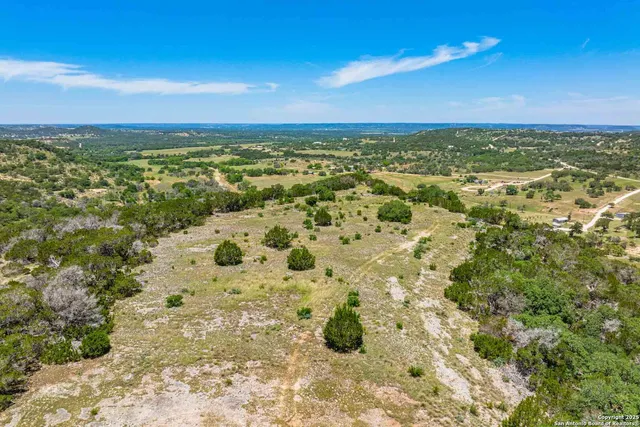 a view of a large yard with lots of green space and house in the back