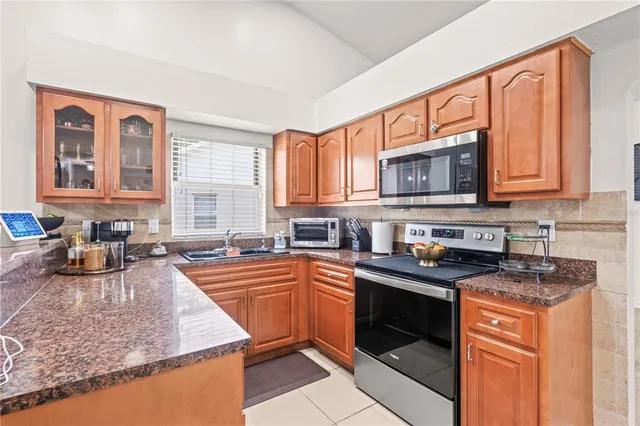 a kitchen with stainless steel appliances granite countertop a stove sink microwave and cabinets