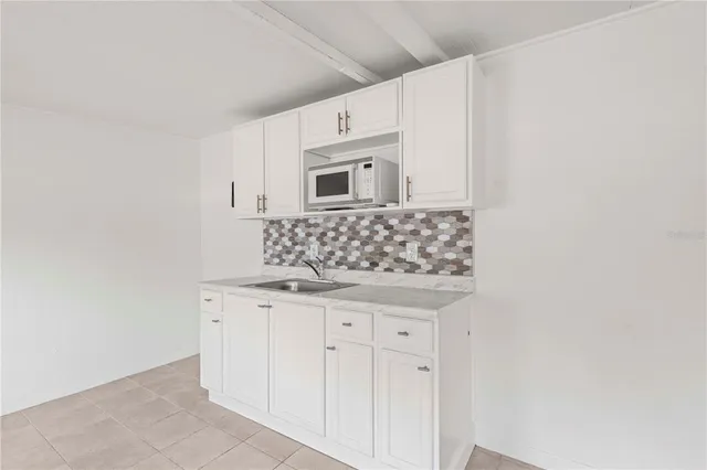 a kitchen with granite countertop white cabinets and sink