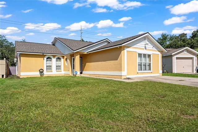 a view of a house with a big yard and large trees