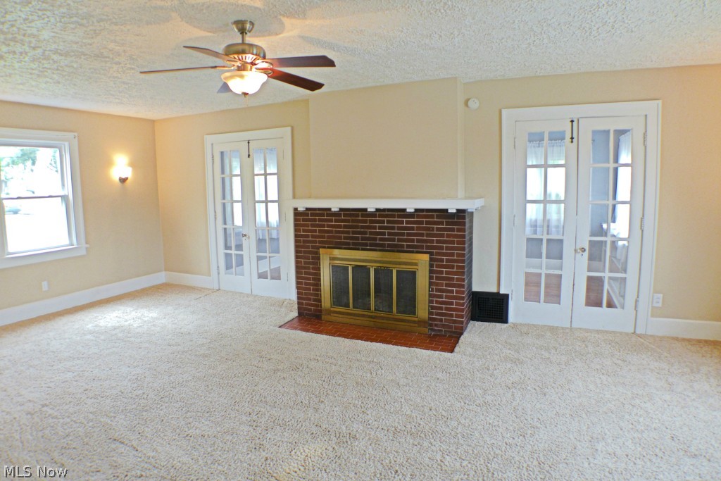 1403 Ridge Road Northwest Canton, OH 44703 - Photo 2 of 20 Living room with fireplace and double doors to the sunroom