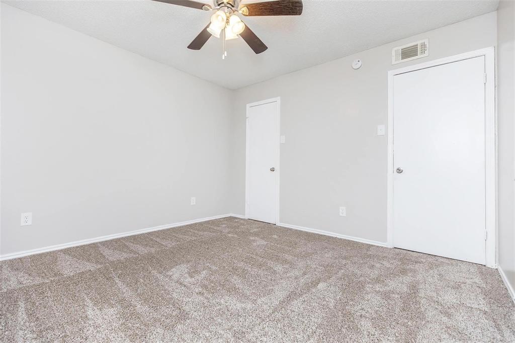 1826 Esters Road, Unit 2009 Irving, TX 75061 - Photo 25 of 39 The room features light gray walls, a textured carpet, and a ceiling fan with integrated lighting
