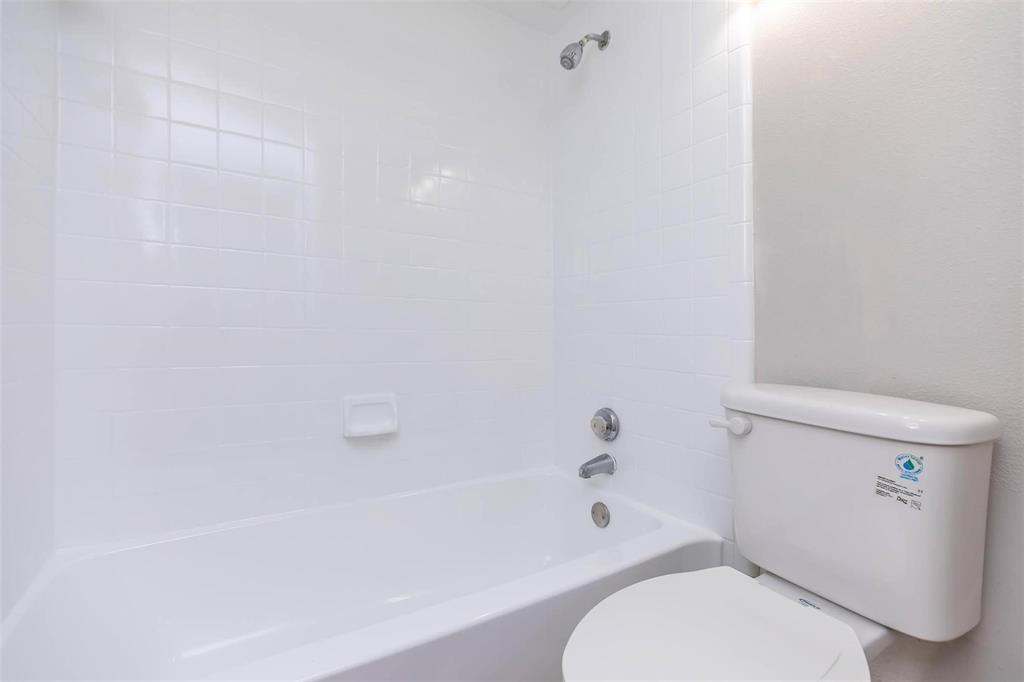 1826 Esters Road, Unit 2009 Irving, TX 75061 - Photo 29 of 39 The bathroom features a clean white bathtub with tiled walls and a white toilet