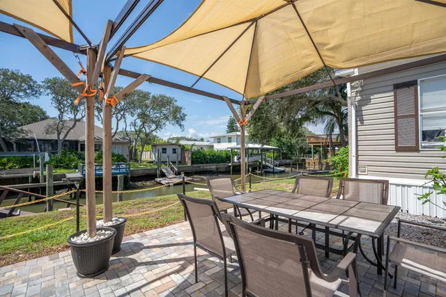 a view of a patio with a table chairs and a backyard