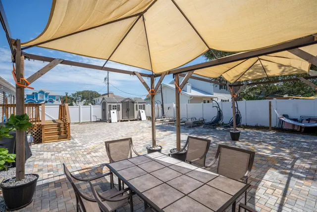 a view of house with backyard and sitting area
