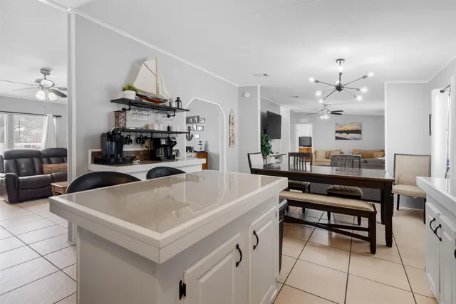 a living room with stainless steel appliances a table chairs and a kitchen view