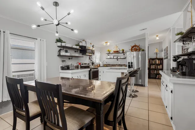 a view of a dining room with furniture and a kitchen